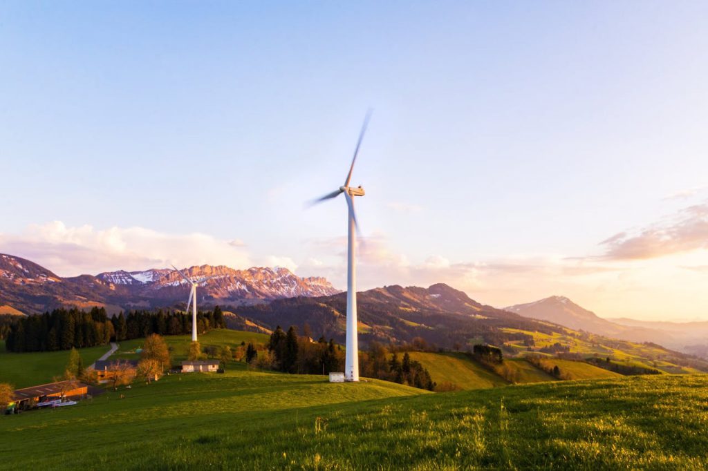 pexels-photo-414807 A wind turbine stands tall against a mountainous backdrop under a vibrant sky at sunset.